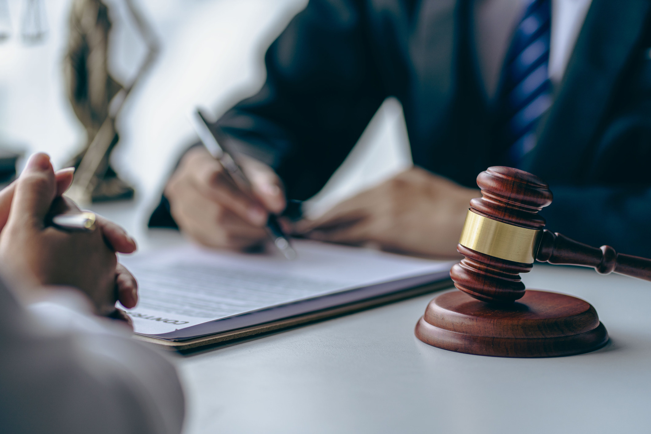 A person at a desk next to a judge&#x27;s gavel