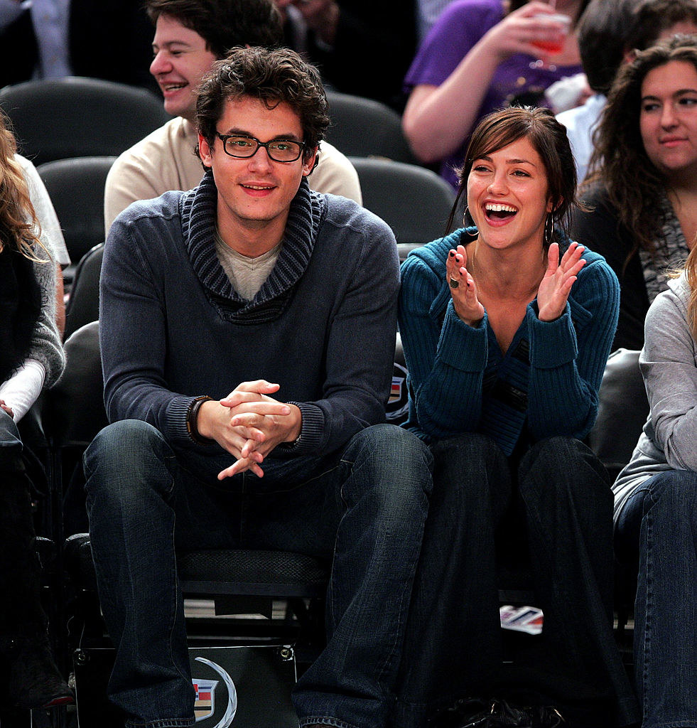 John and Minka sitting in the audience at a sports event
