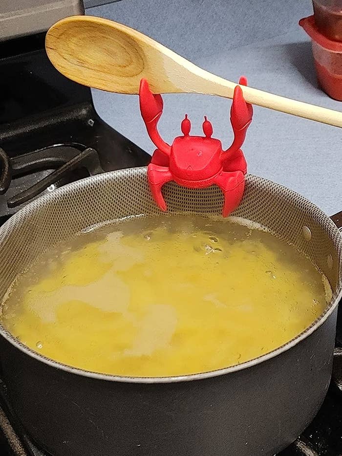Wooden spoon in crab holder on a cooking pot