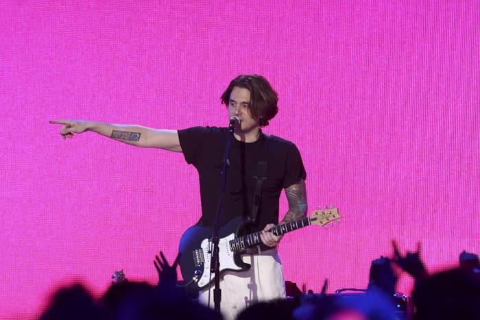 John performing onstage as he points to the crowd
