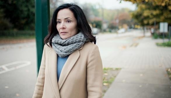 A woman standing in the street looking nervous