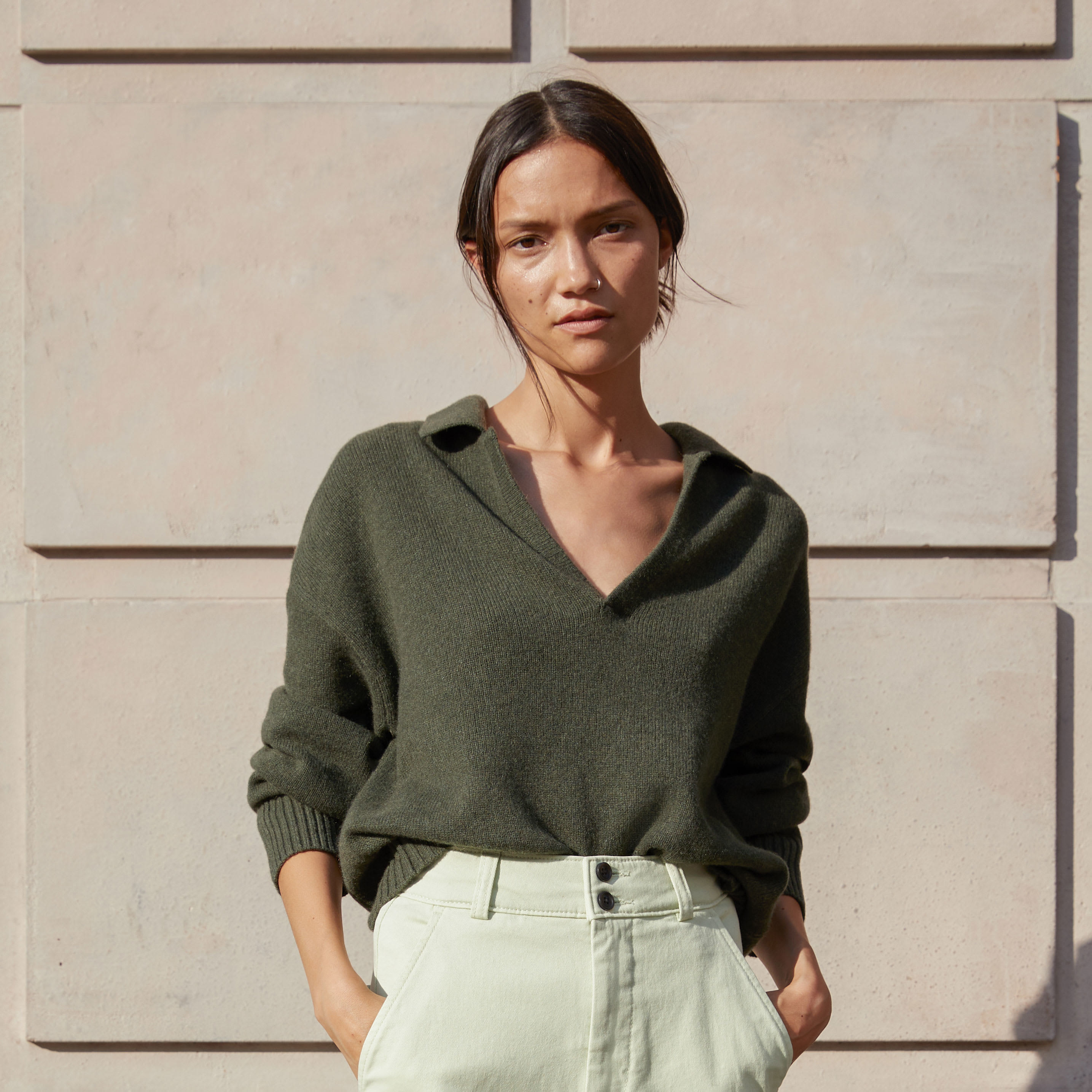 A model in the dark olive green sweater