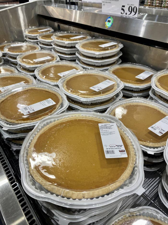 multiple pumpkin pies in refrigerator case