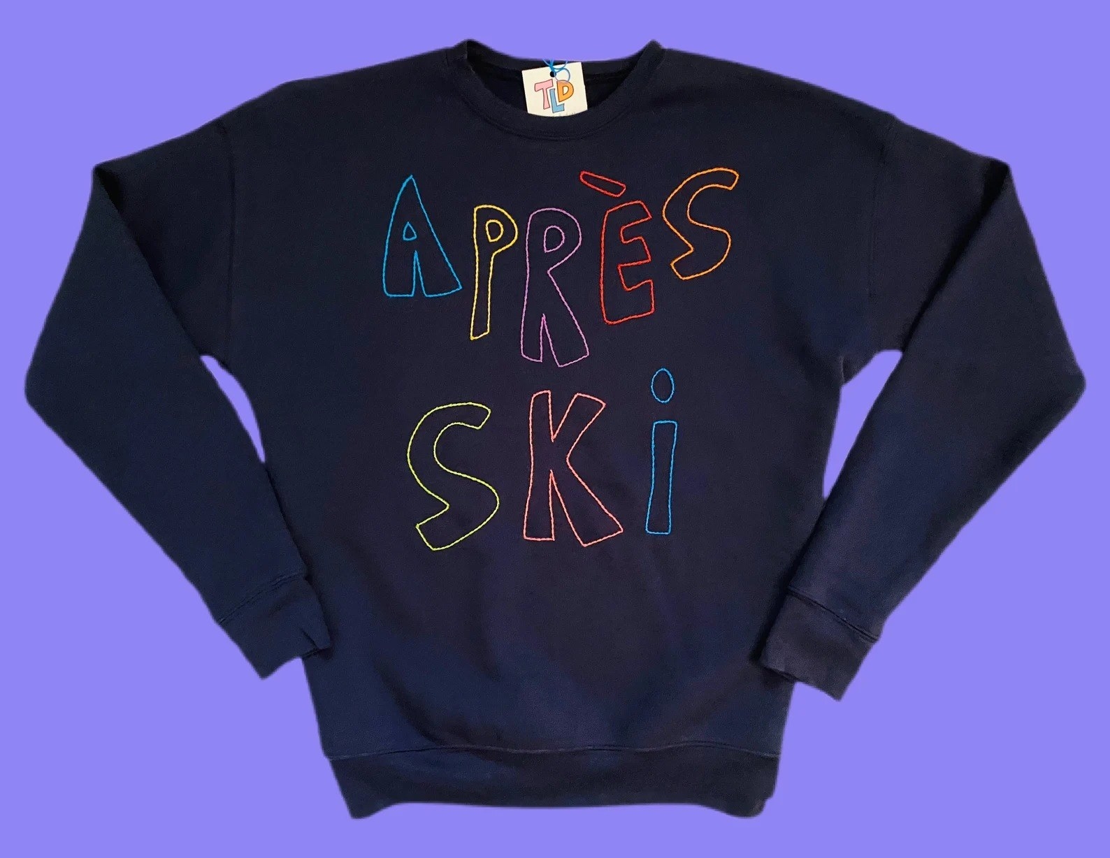 The navy sweatshirt with &quot;apres ski&quot; embroidered in multicolor thread