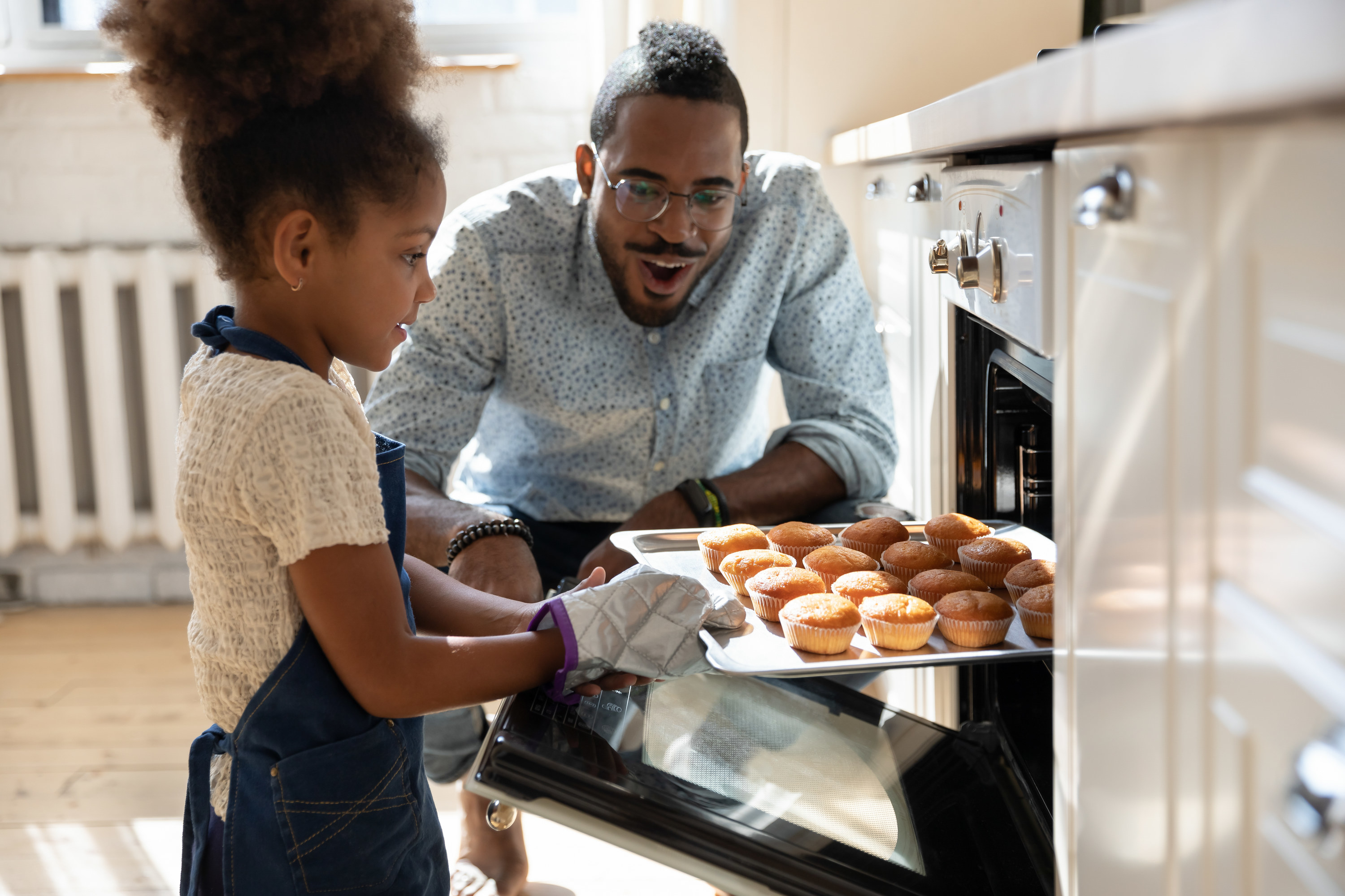 A father and daughter baking muffins