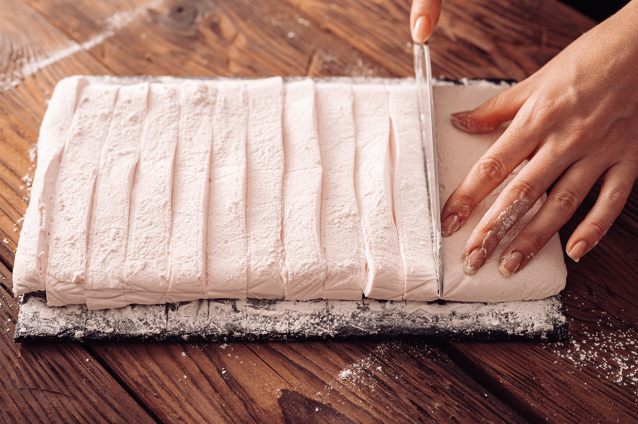 Hand cutting strips of marshmallows