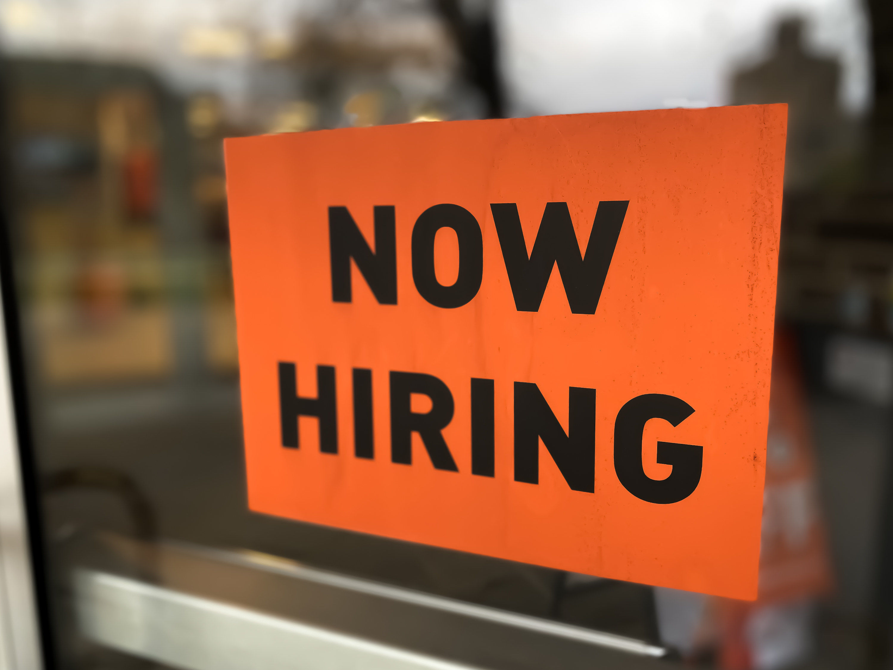 &quot;now hiring&quot; sign in a window