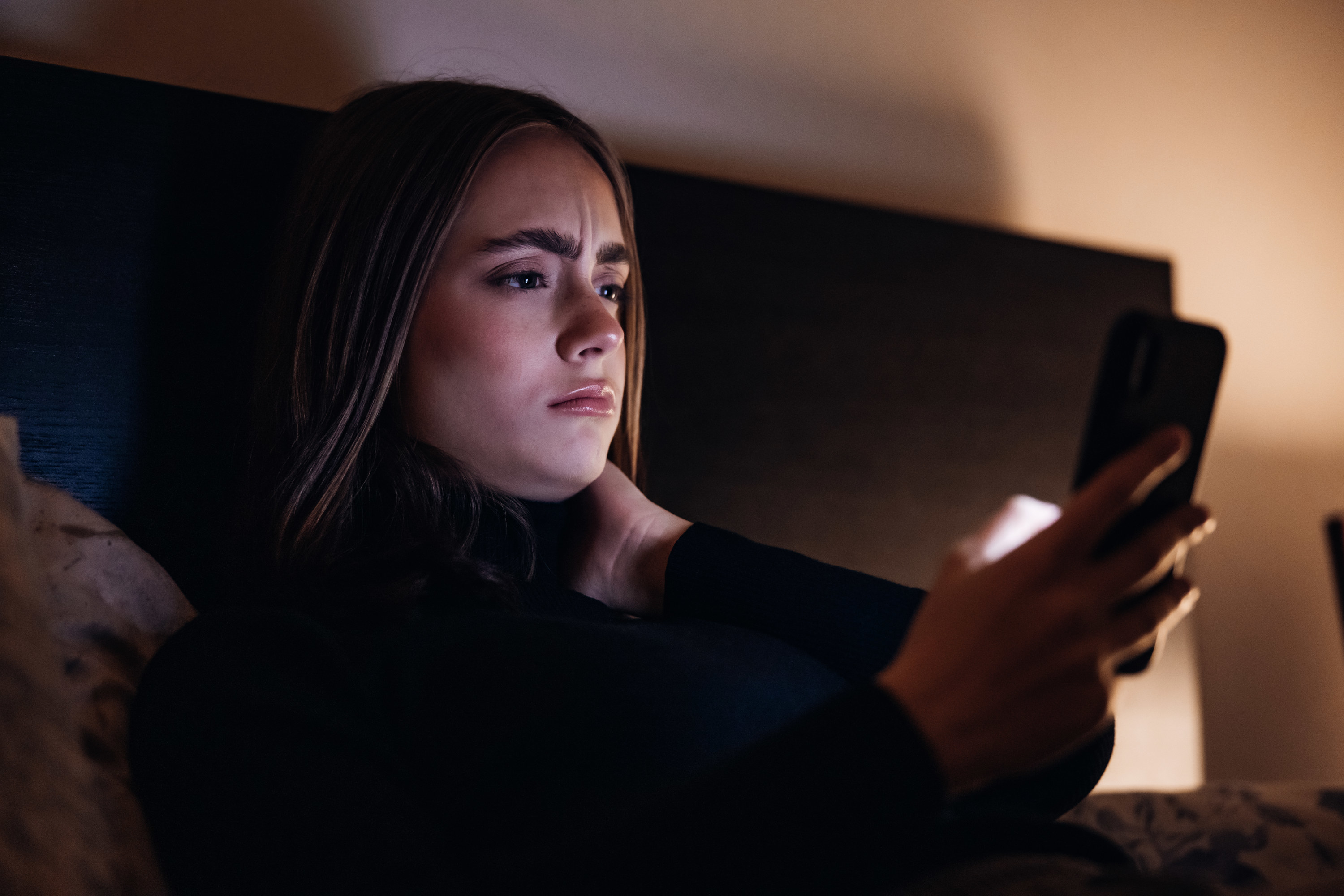 A woman looking confused on her cellphone