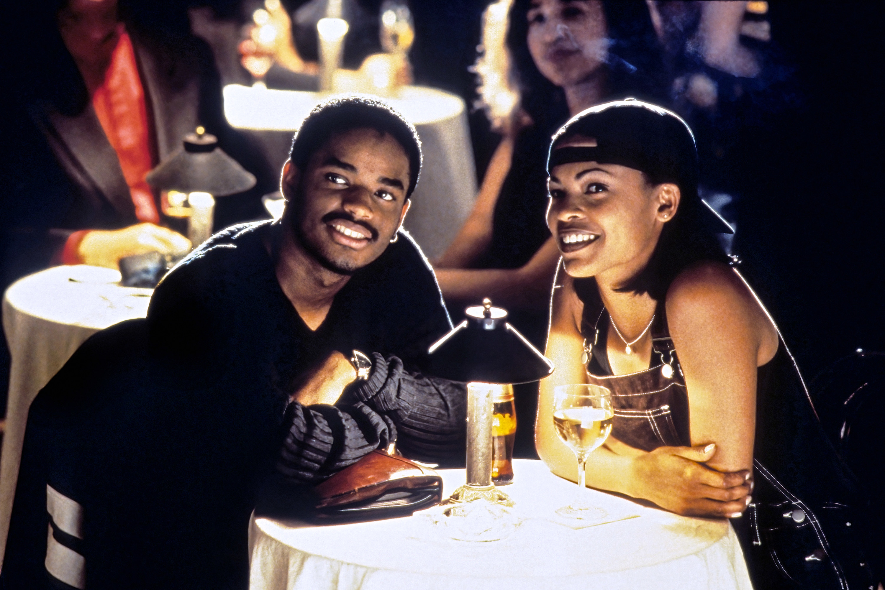 Nia and Larenz sitting at a table with drinks in a scene from the film