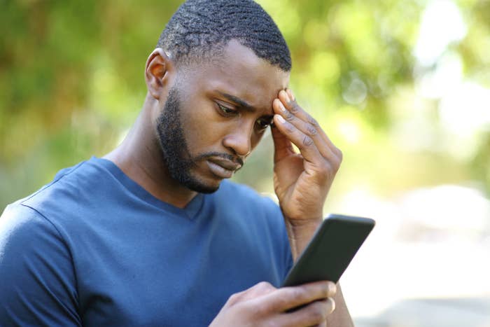 Worried man checking smartphone in a park