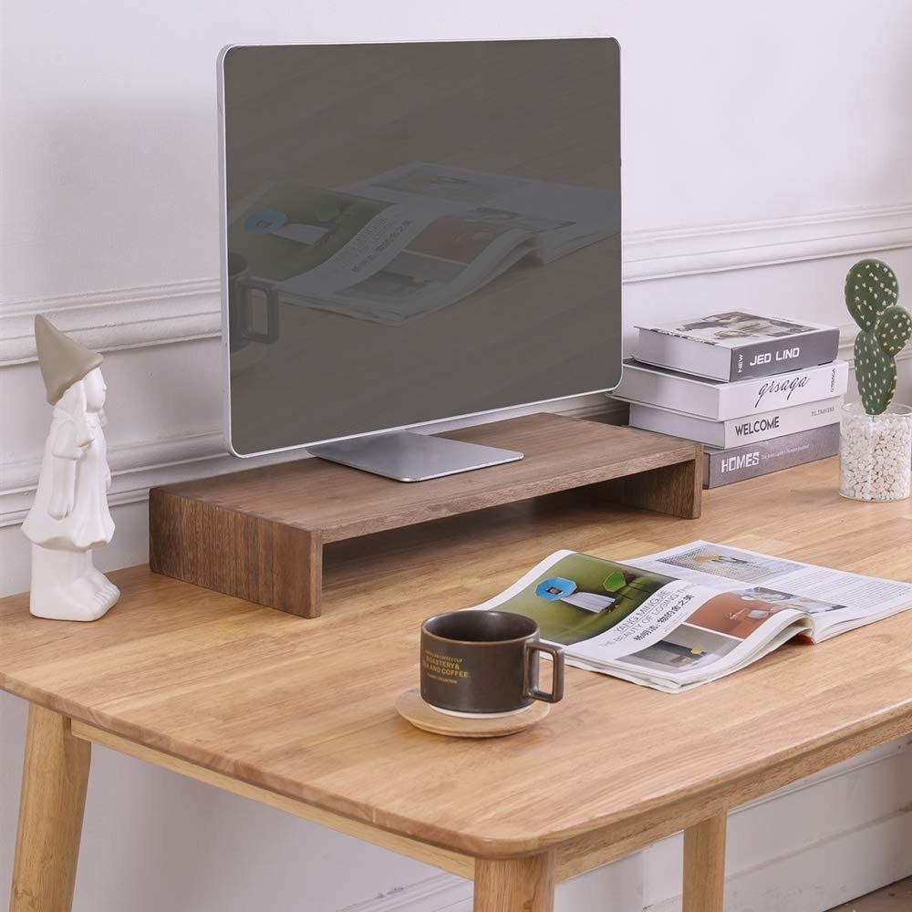 a laptop on a wooden desk riser