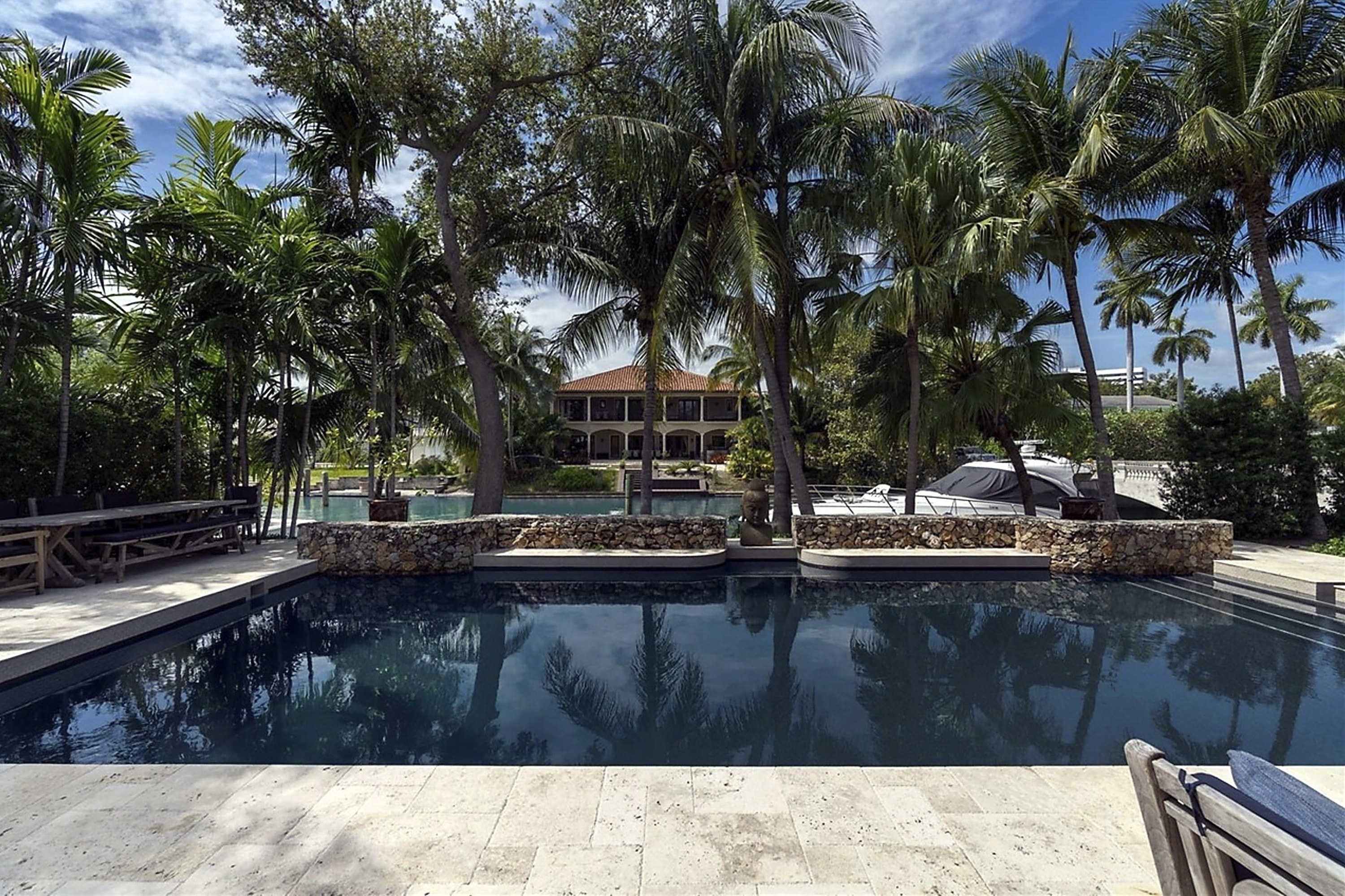 Large sunken rectangular pool surrounded by palm trees