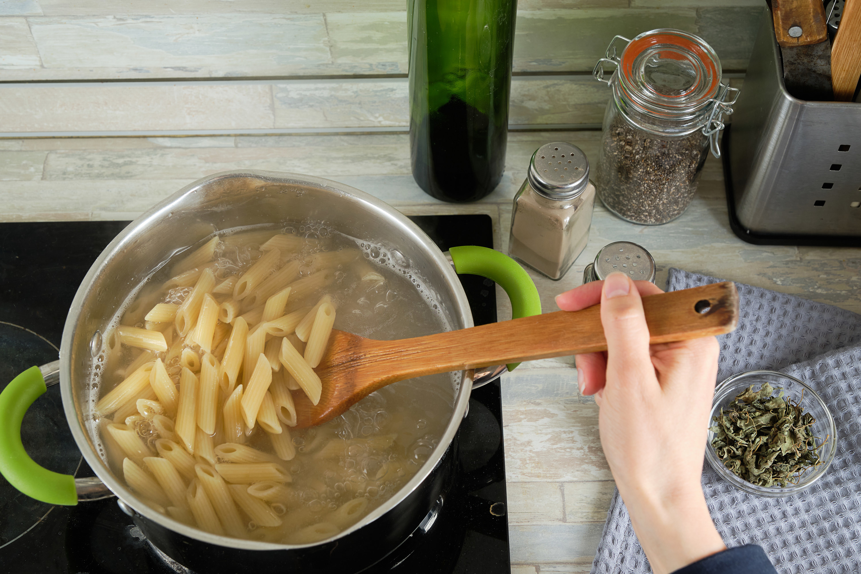 person stirring a pot of boiling pasta