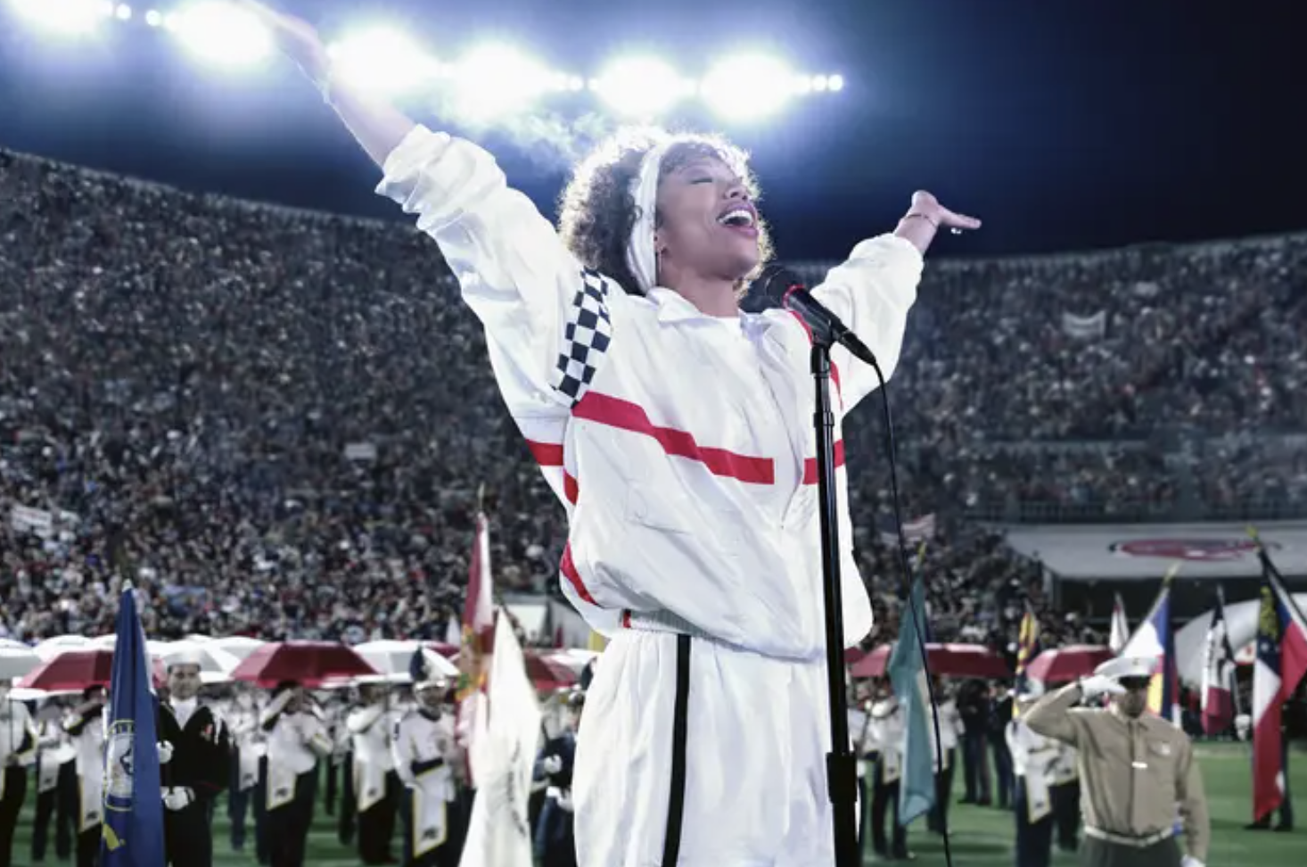 Naomi Ackie as Whitney Houston singing in a crowded football stadium