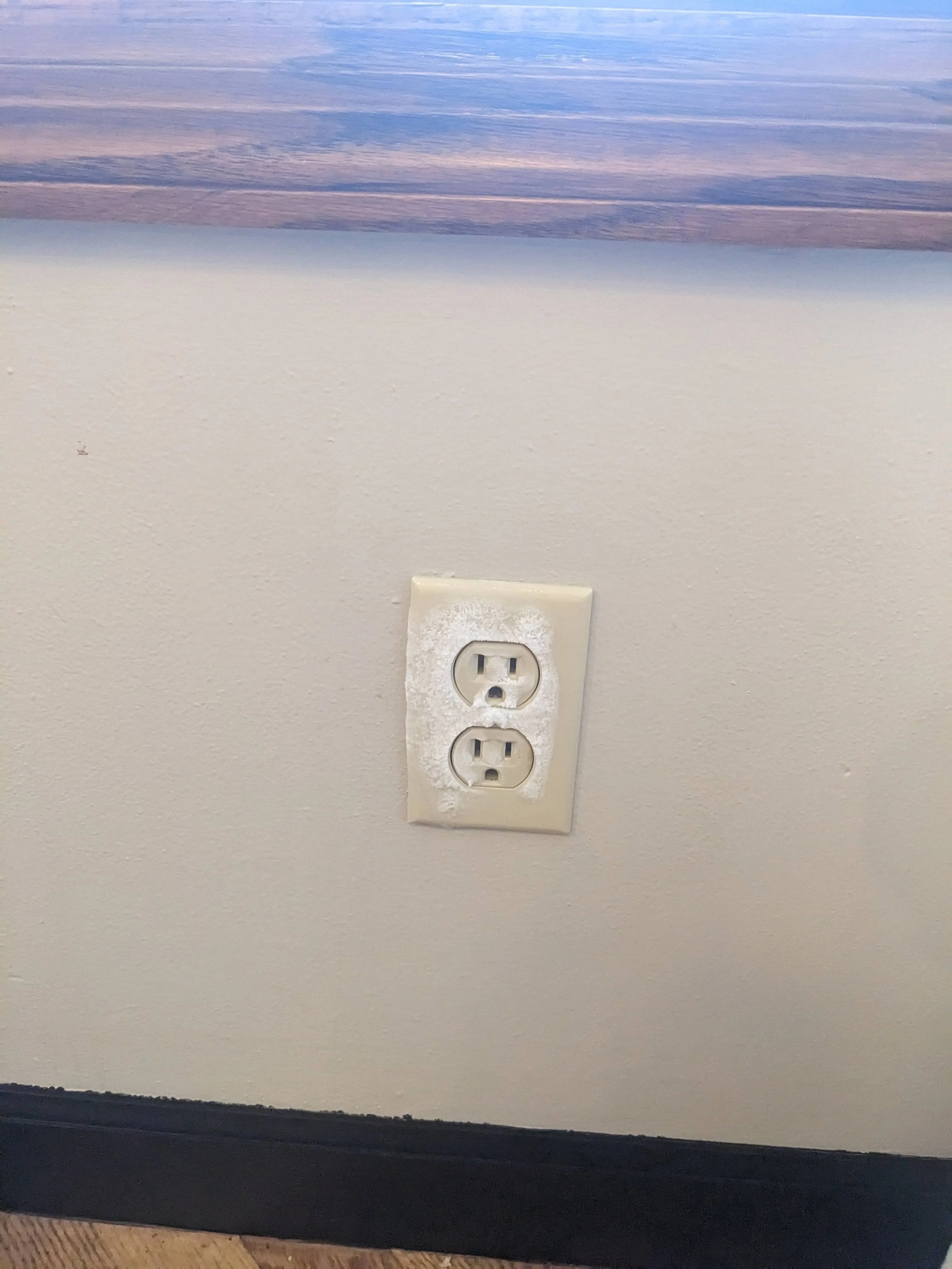 An electric outlet with frost on it