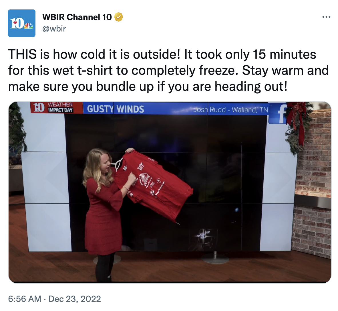 A woman holding up a frozen shirt with text explaining it only took 15 minutes for the wet T-shirt to freeze