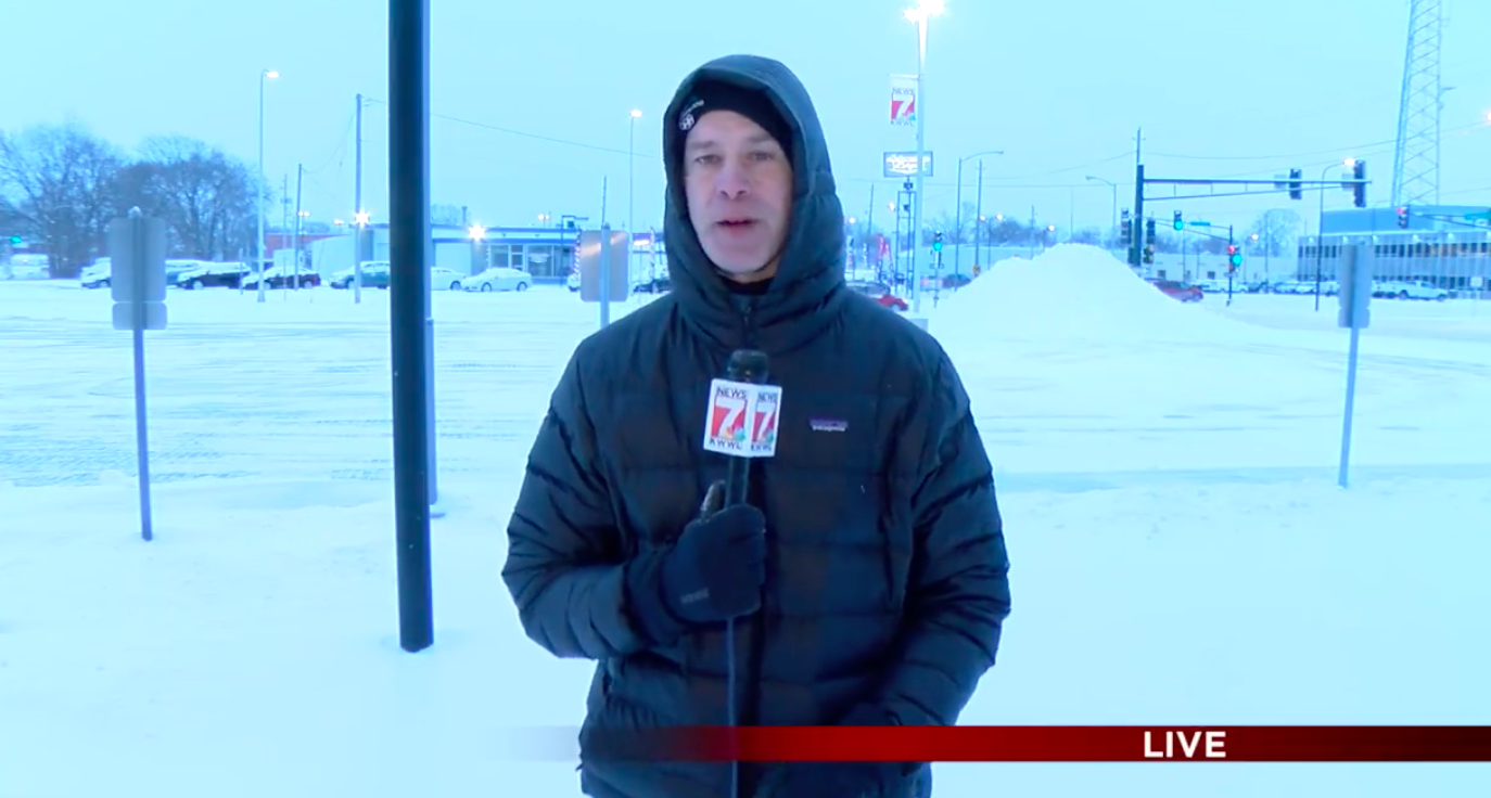 Reporter standing with snow behind him