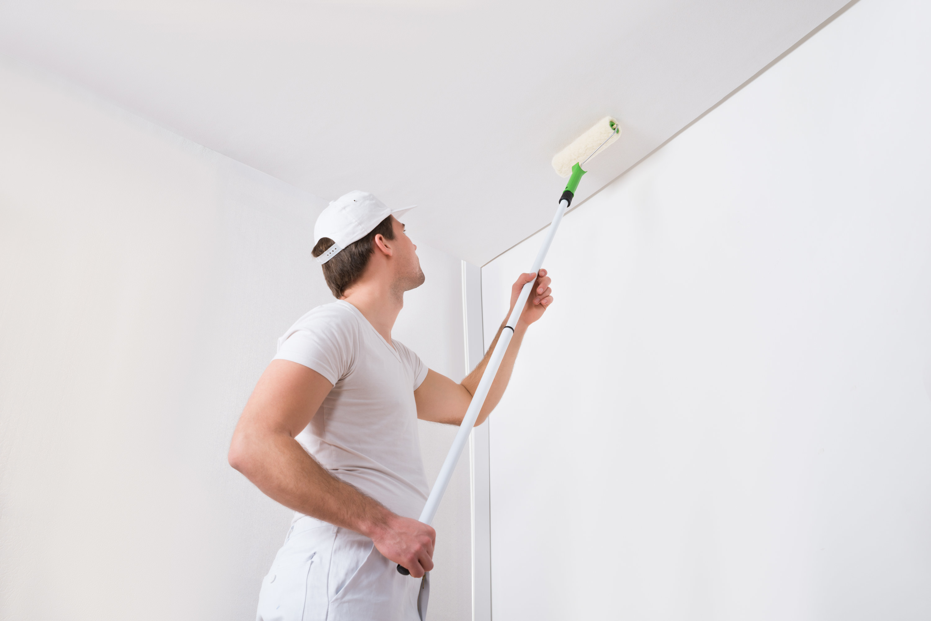 person painting a ceiling white