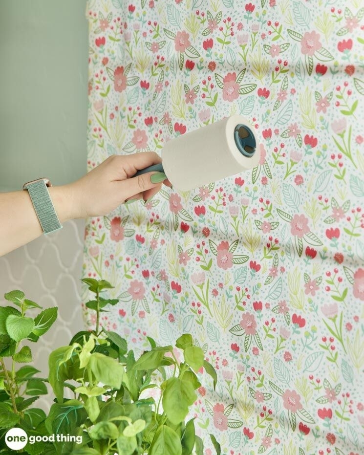 Blogger&#x27;s photo of a hand passing a lint roller over drapes