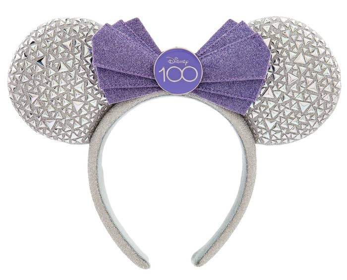 Minnie ear headband with triangle-shaped appliques and a folded, angular bow, and a D100 logo pin in the middle of the bow