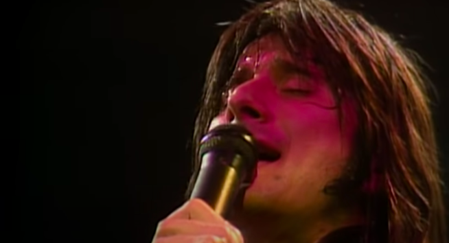 A man sings passionately into a microphone he&#x27;s holding
