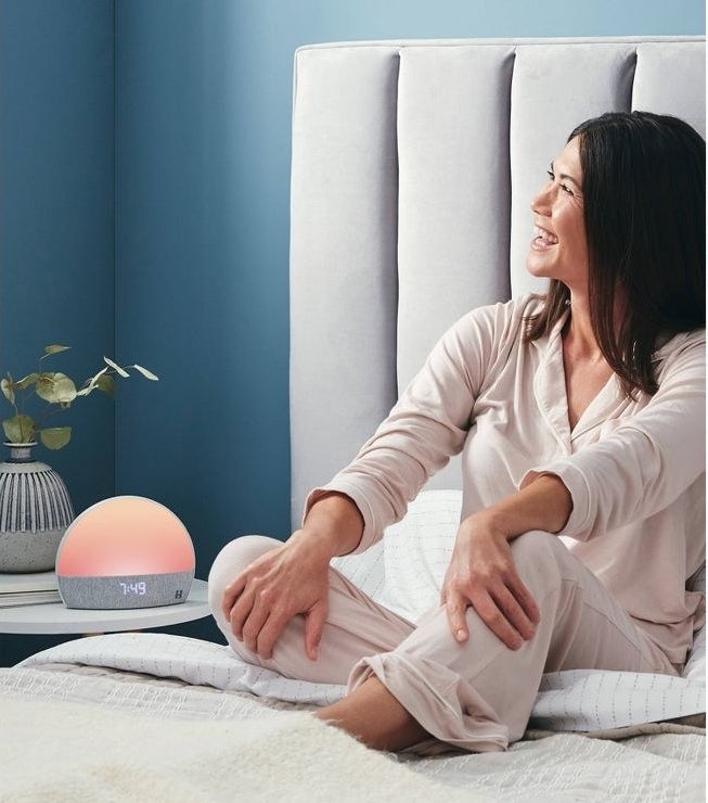 model sitting on bed next to Hatch alarm