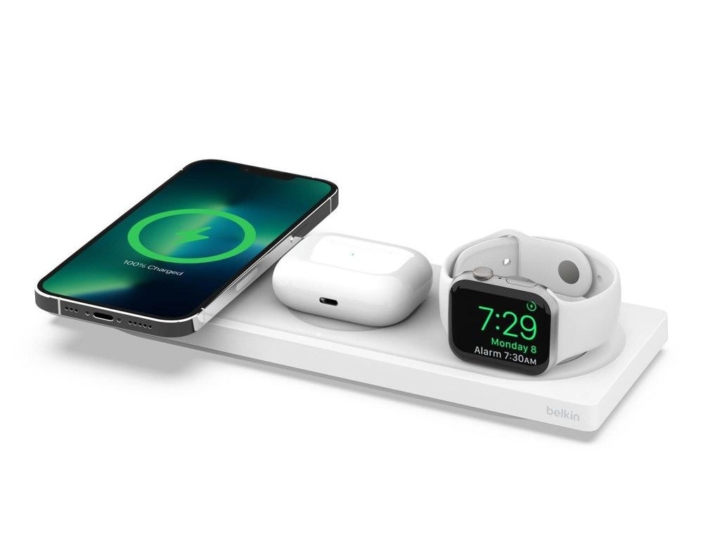 white wireless charging pad with a phone, air pods, and smart watch on top