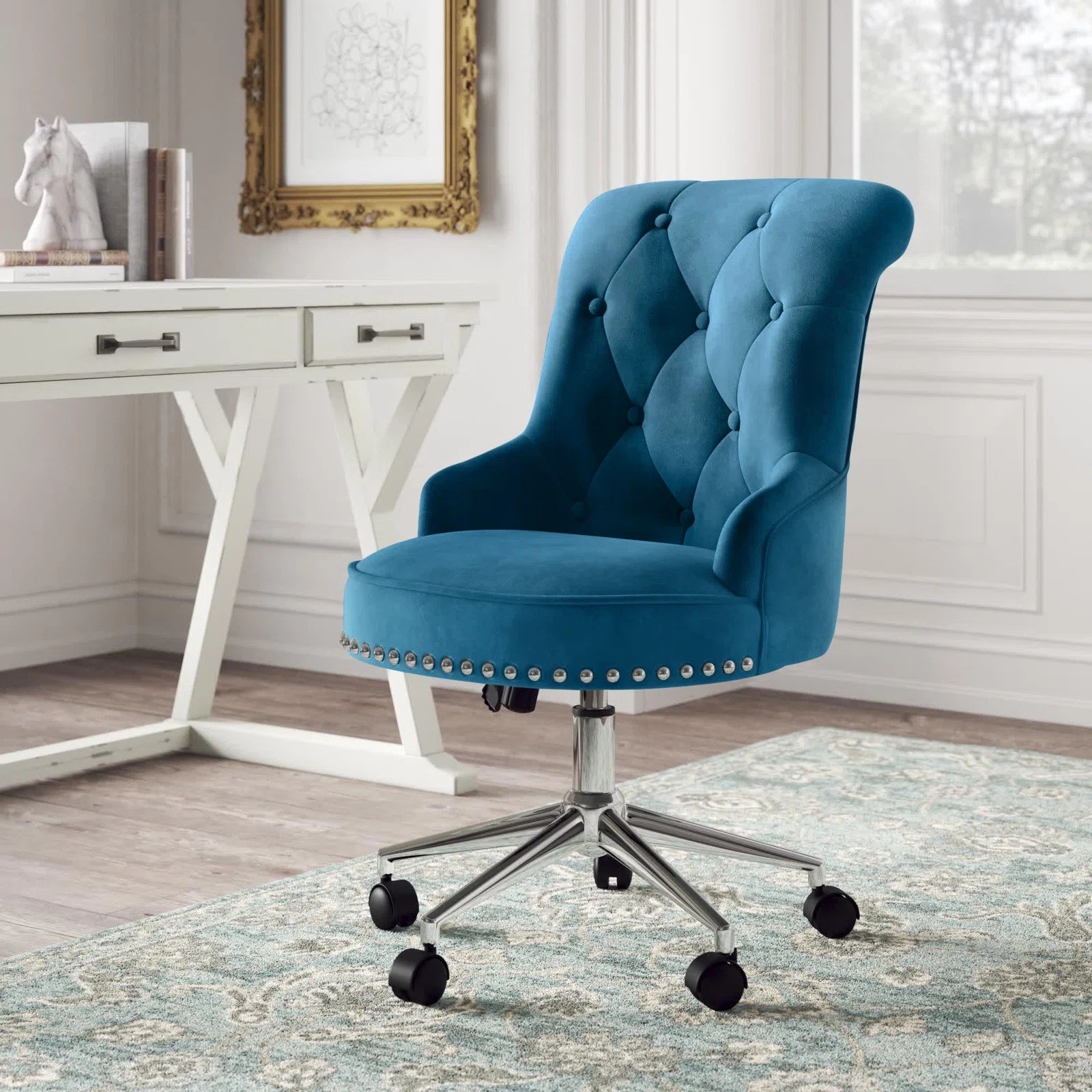 Blue velvet task chair on carpet next to a desk