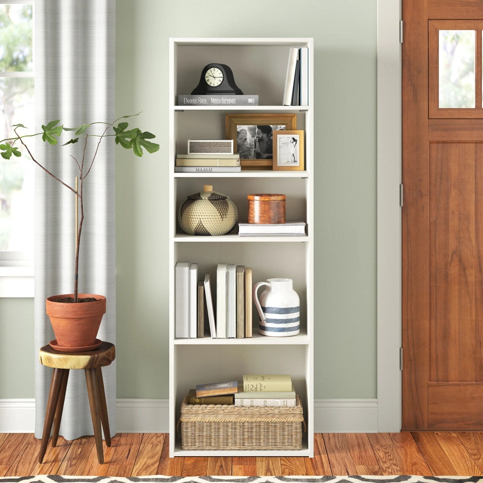 White bookcase in a living room next to a stool