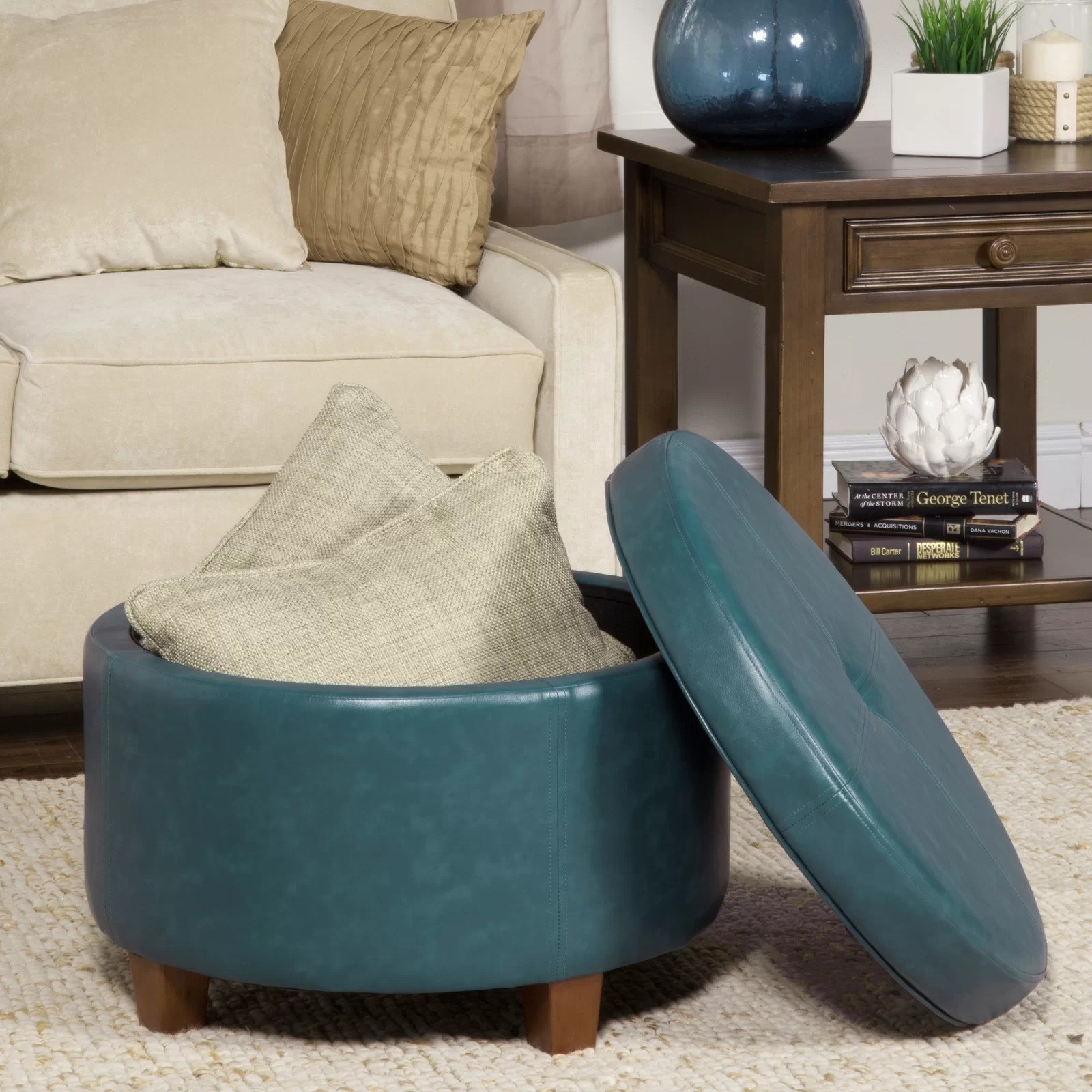 Teal faux leather storage ottoman on a carpet in a living room