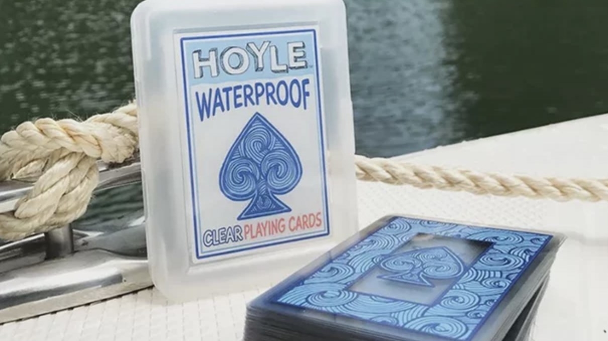 The clear waterproof cards on boat deck with carrying case behind them