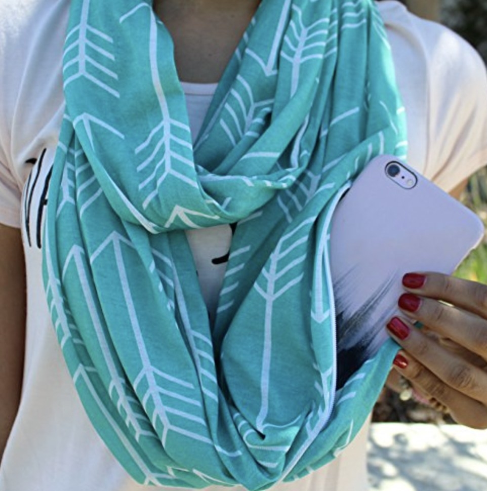 model wearing the blue scarf and slipping phone out of pocket