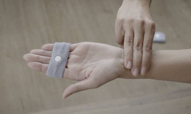 Someone with grey wrist set  slipped implicit    fingers and pressing fingers connected  the acupressure constituent   connected  wrist wherever  the set  usually   rests