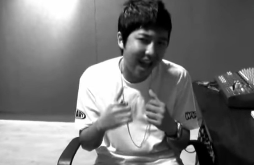 A young RM raps while smiling at the camera