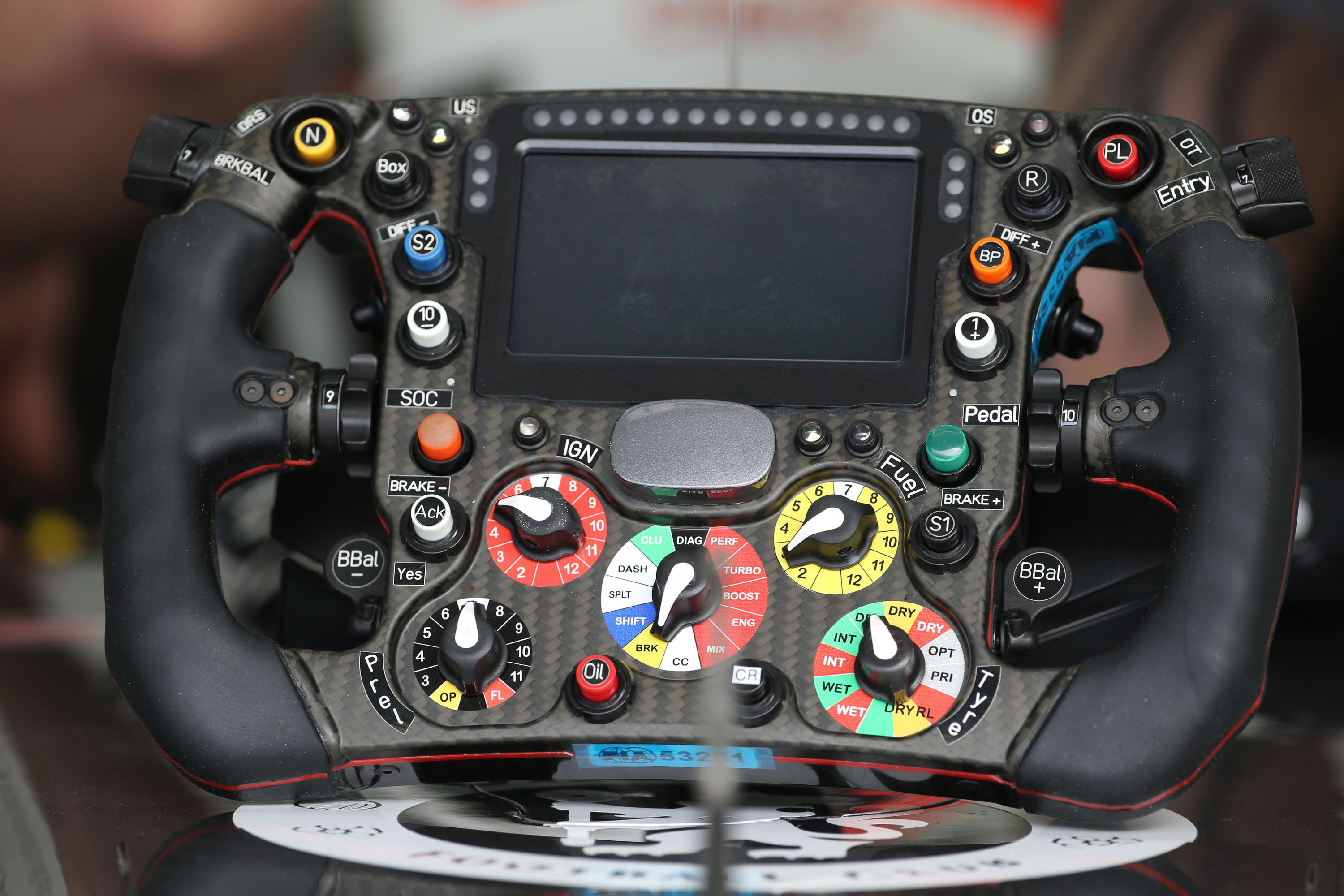 A steering wheel with many controls of different colors