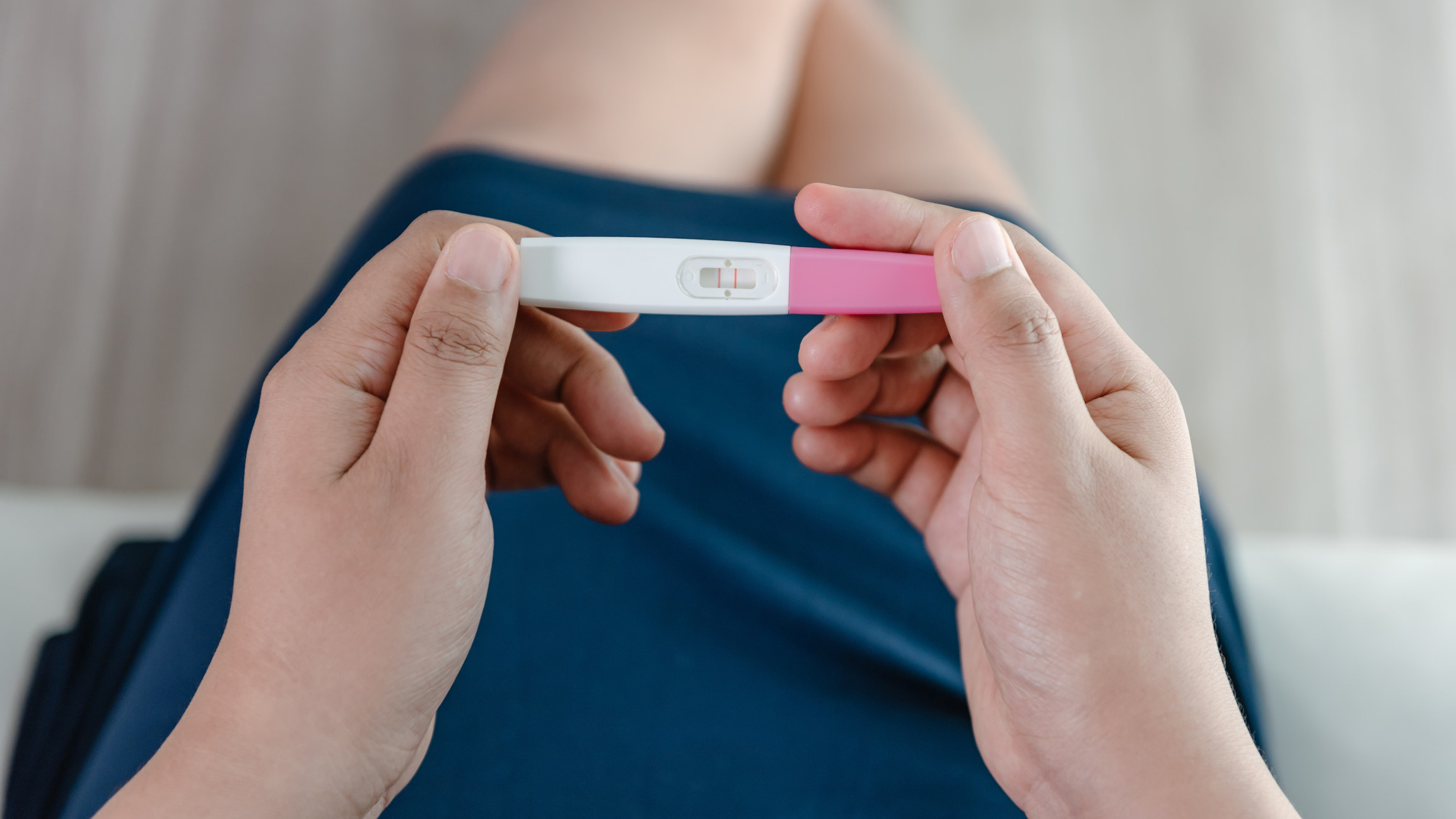 a woman looking at a pregnancy test