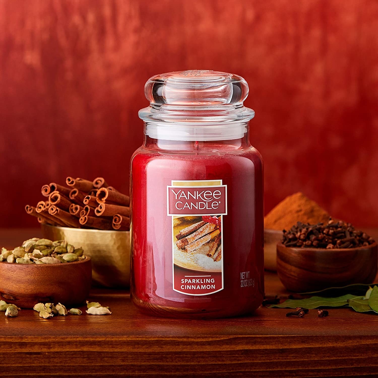 The sparkling cinnamon candle surrounded by bowls of spices.