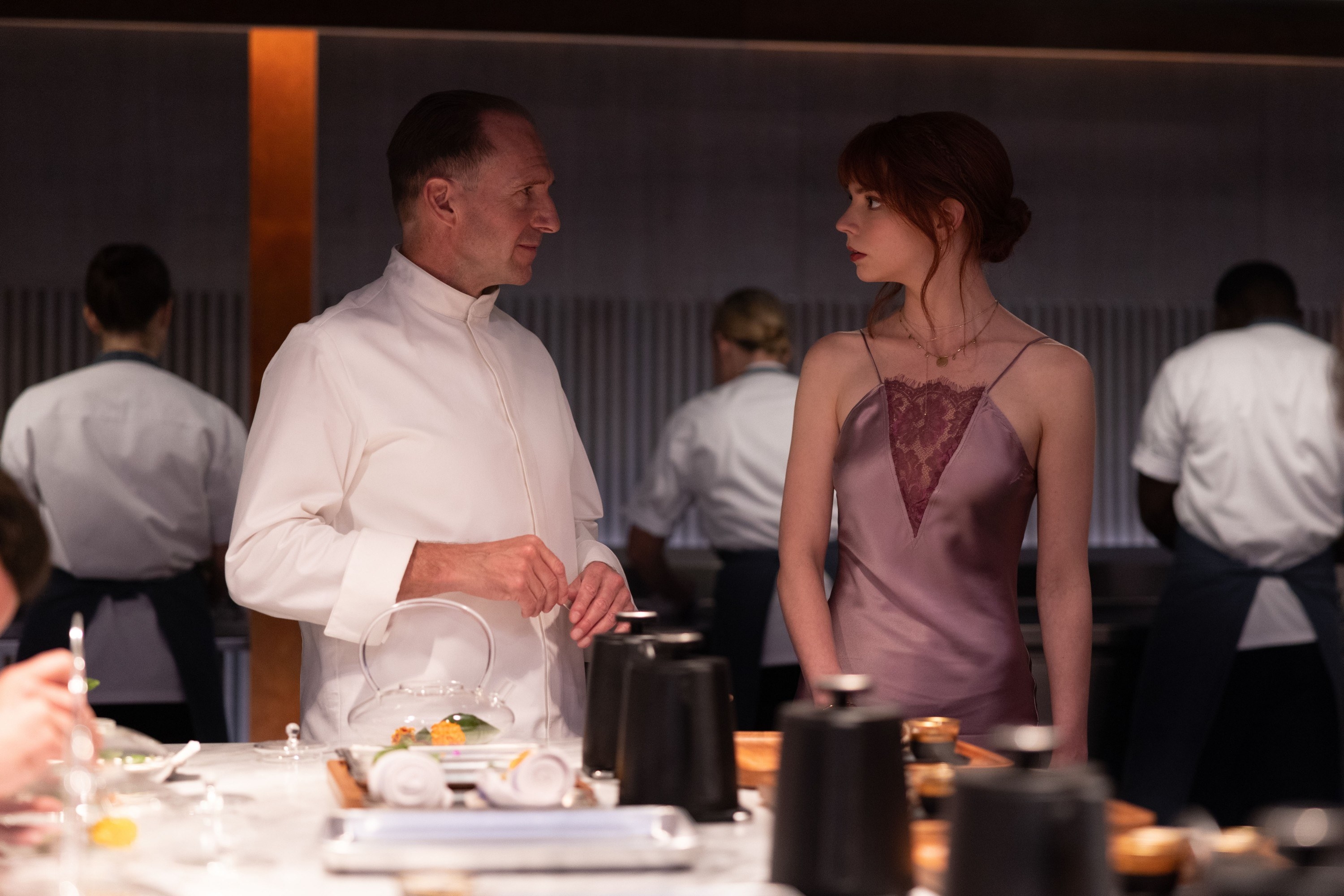 Ralph Fiennes and Anya Taylor-Joy stand in a kitchen
