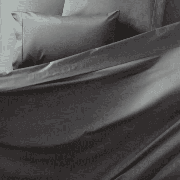 gif of gray bedsheets falling onto a bed