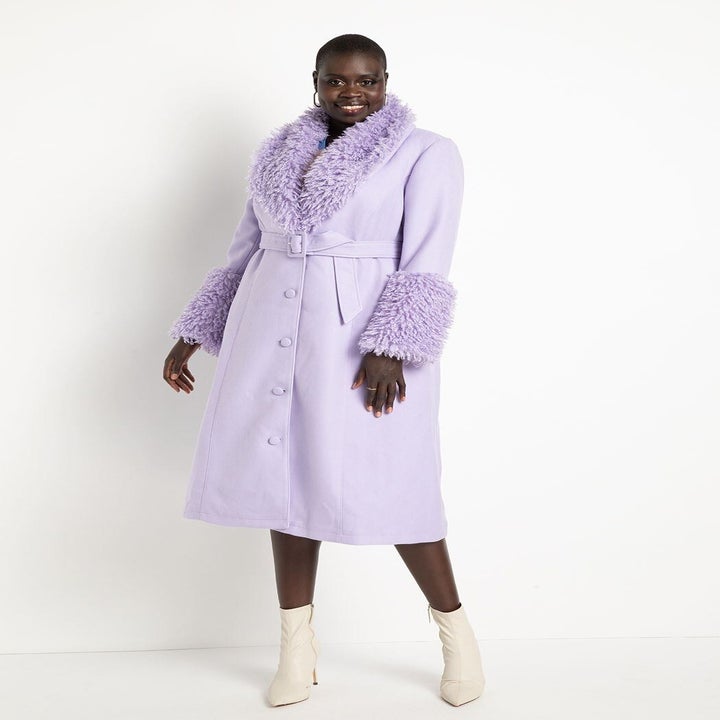 model in long belted light purple coat with fuzzy cuff and collar details