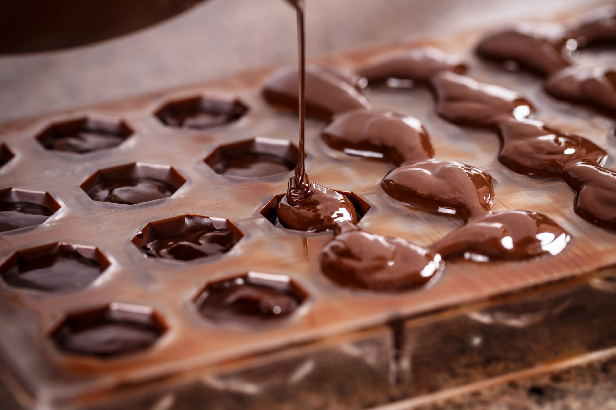 Pouring melted chocolate into a mold.