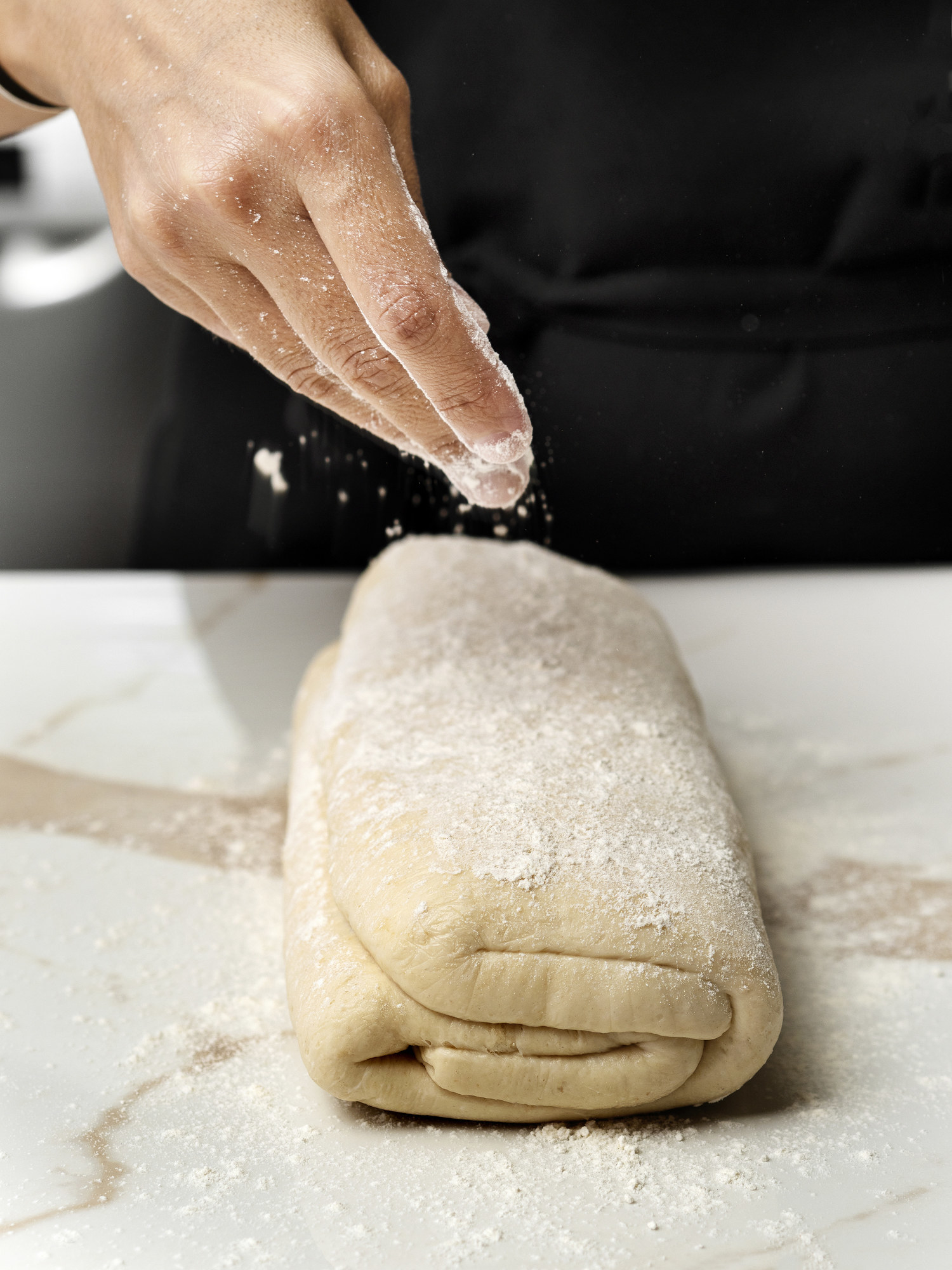A person preparing croissant dough.