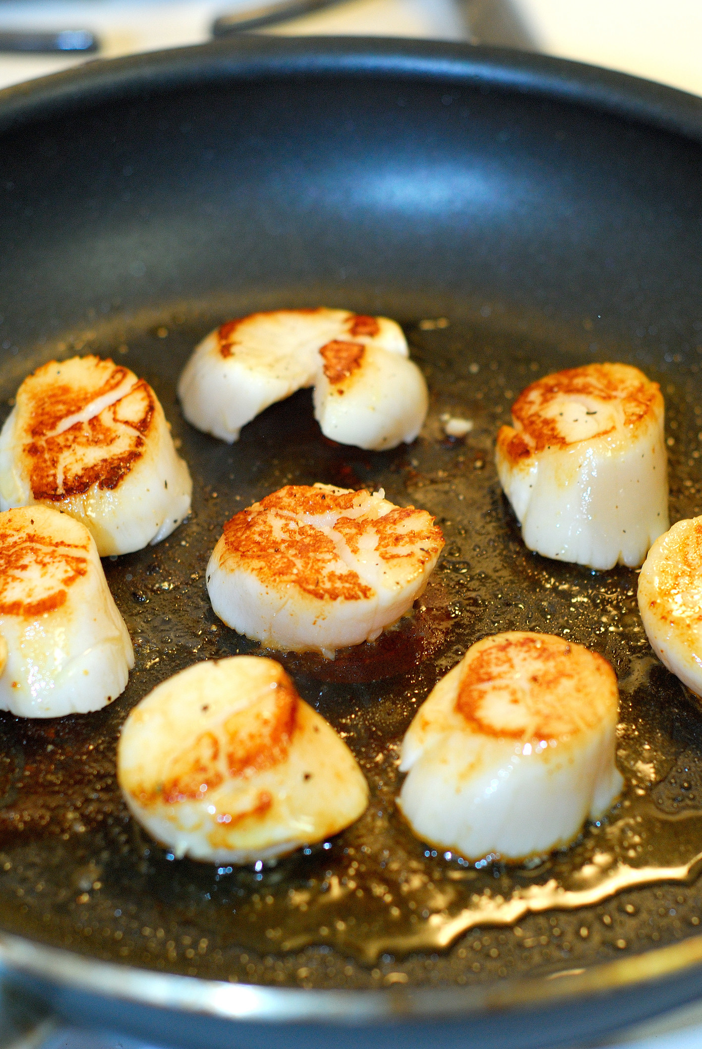 Scallops cooking in a skillet.