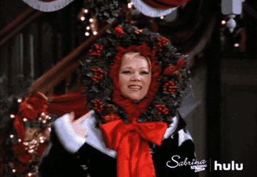 Aunt Hilda magically lights up a festive wreath that sits around her face