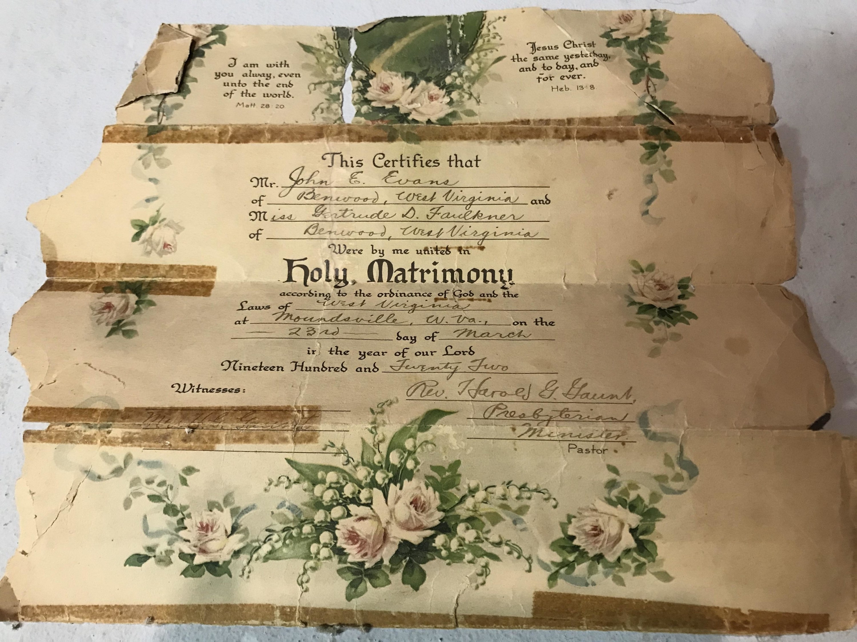 A frayed, yellowed, folded sheet from 1922 with flowers on it