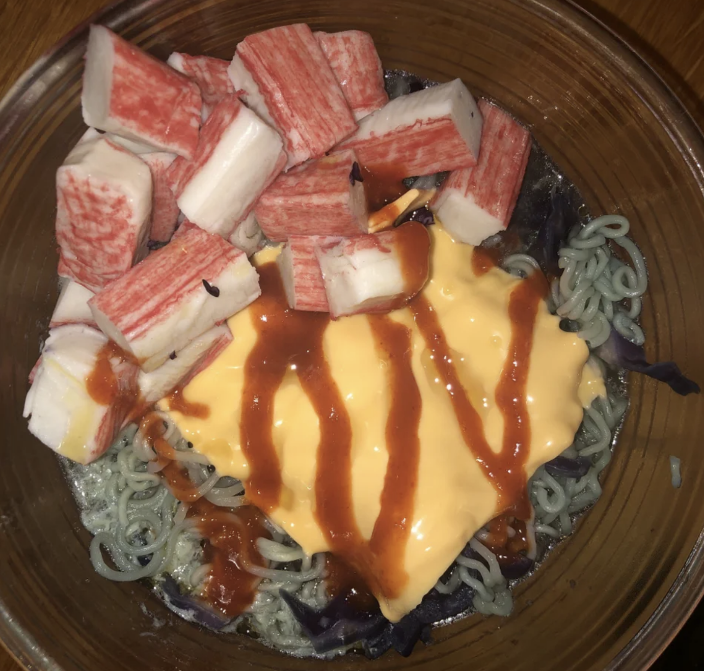ramen with American cheese, pieces of unidentifiable meat, and a red sauce on top