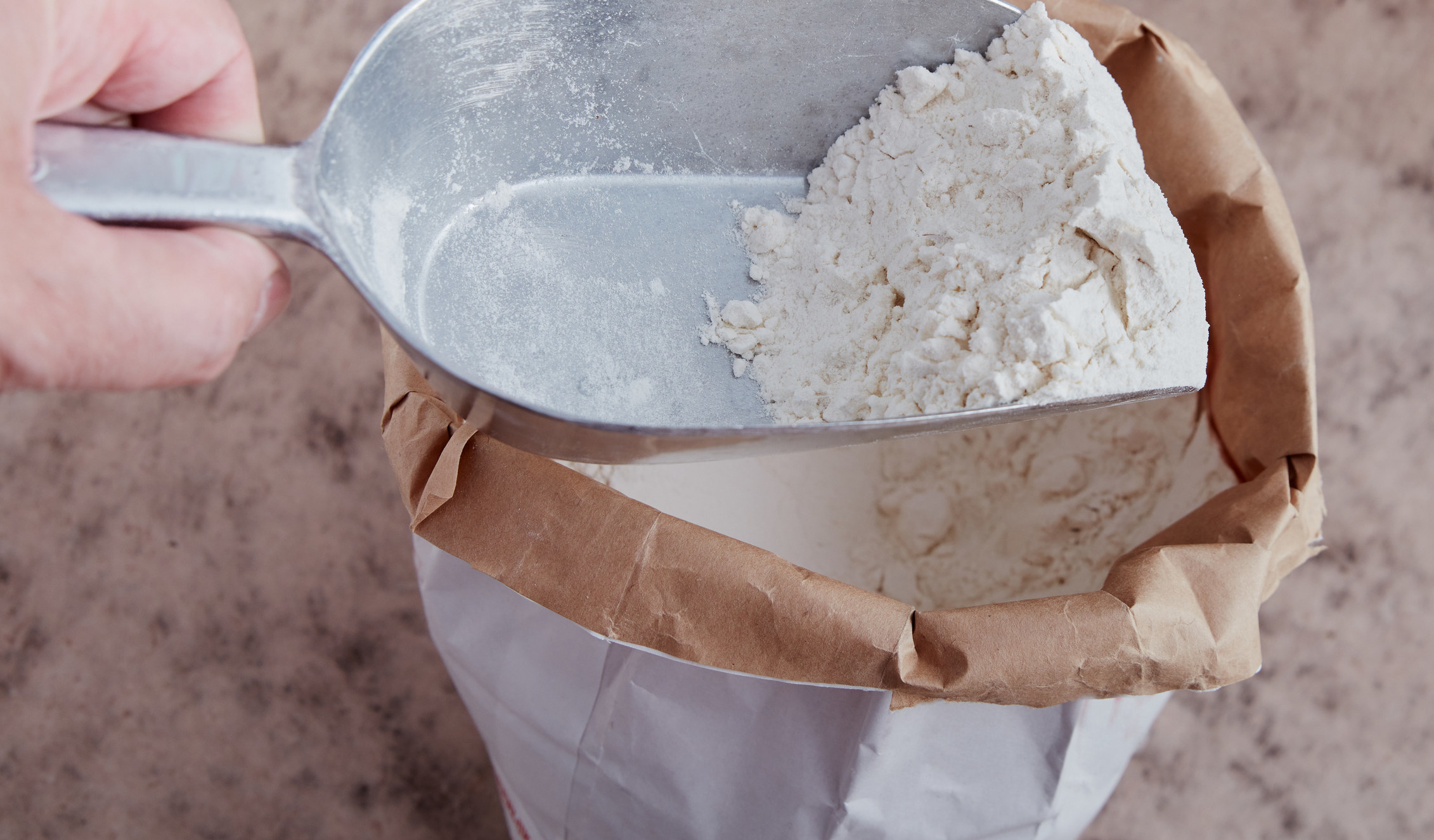 Person scoops up flour from bag