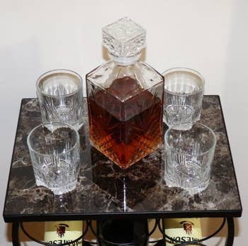 reviewer's the 7-piece whiskey set on a display stand