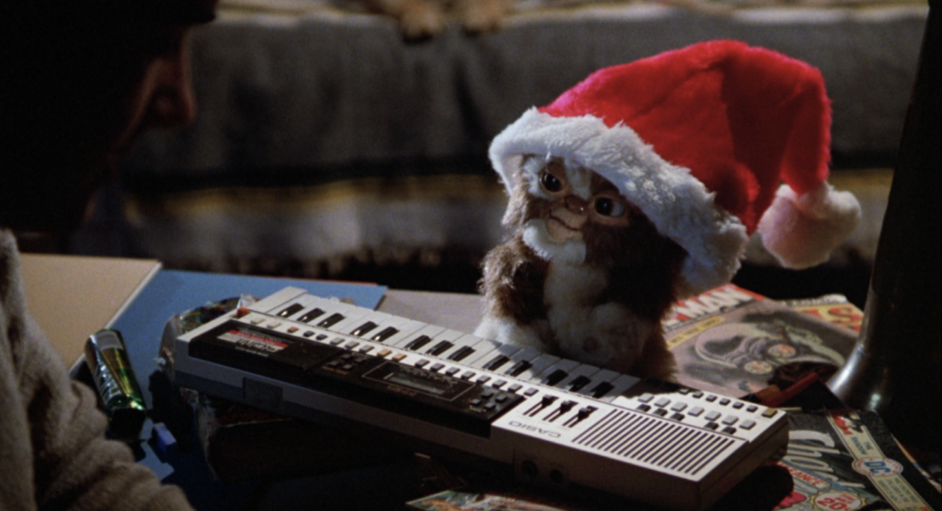 gizmo from gremlins in santa hat playing a keyboard