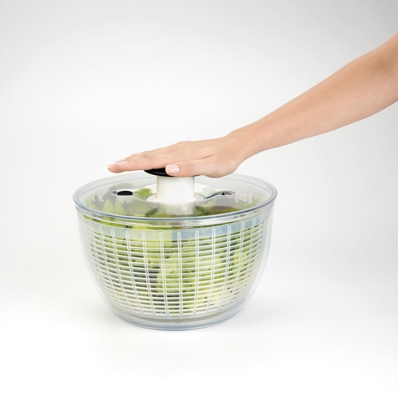 a person uses the salad spinner